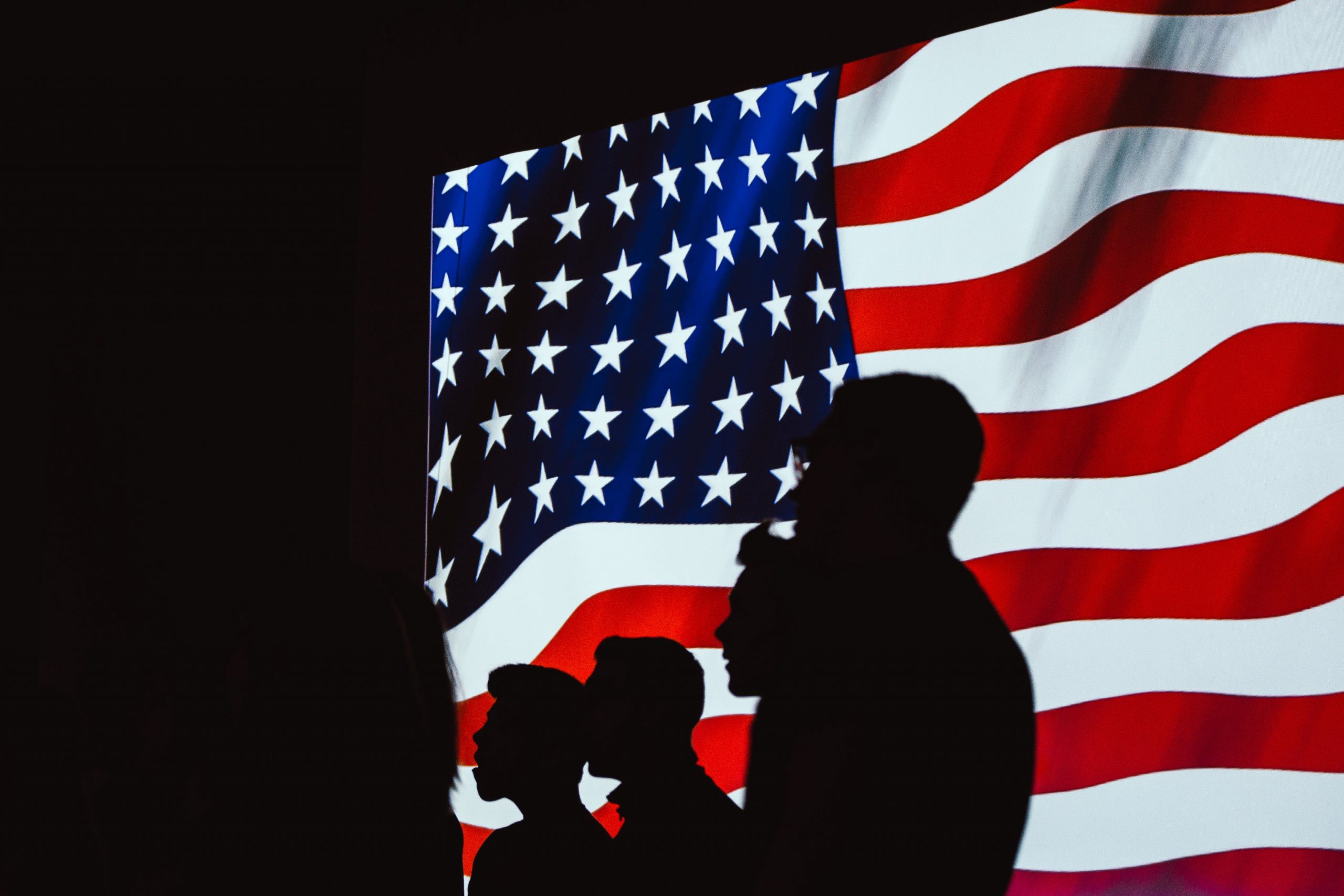 Sombra de personas ante la bandera americana